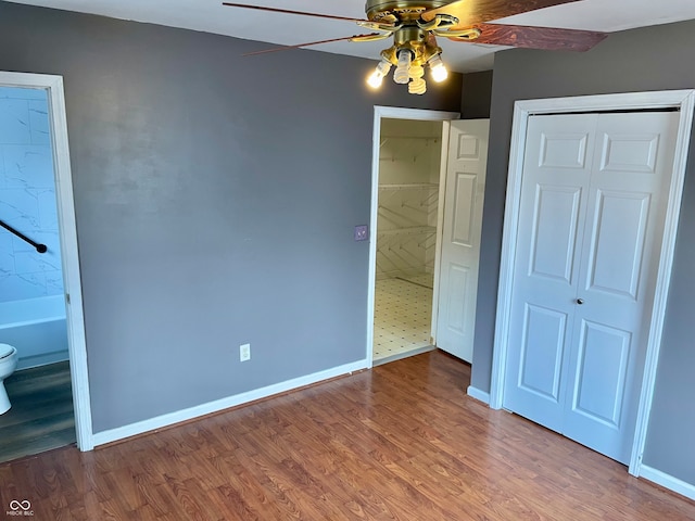 unfurnished bedroom with connected bathroom, ceiling fan, and hardwood / wood-style flooring