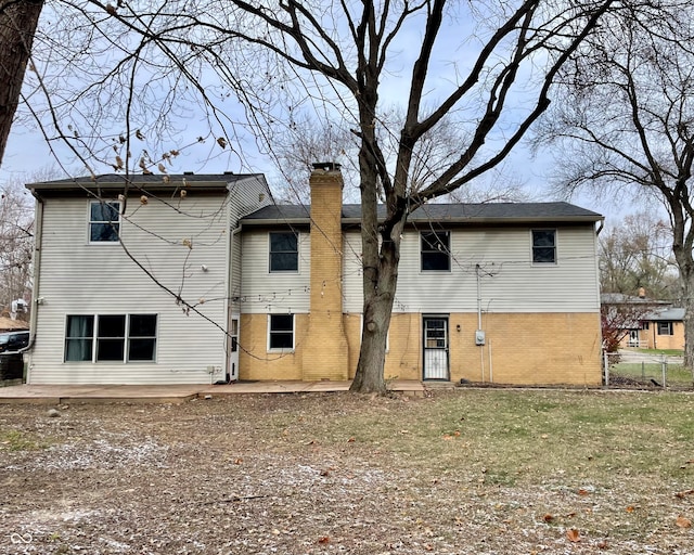 rear view of property with a lawn and a patio