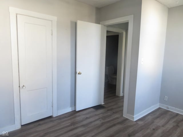 unfurnished bedroom featuring dark hardwood / wood-style floors and a closet