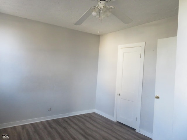 spare room with ceiling fan and dark hardwood / wood-style flooring