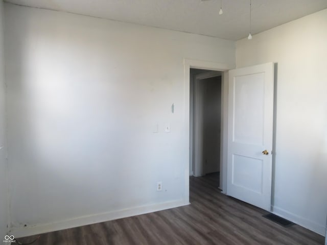 spare room featuring dark wood-type flooring