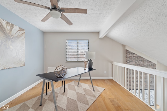 office with vaulted ceiling with beams, ceiling fan, a textured ceiling, and light hardwood / wood-style flooring