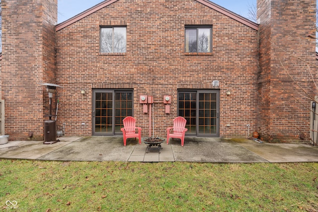 rear view of house with a lawn and a patio