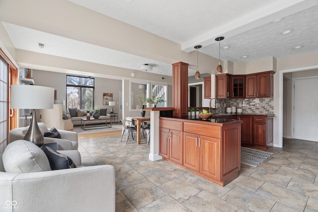 kitchen with tasteful backsplash, a textured ceiling, sink, decorative light fixtures, and beamed ceiling