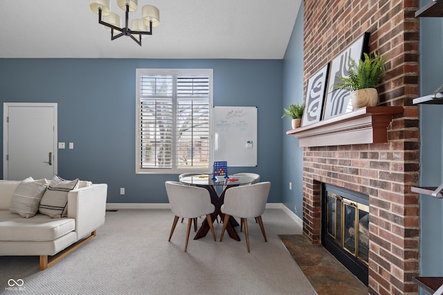 dining room with carpet, a chandelier, and a fireplace