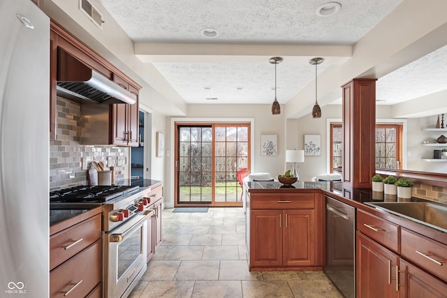 kitchen with hanging light fixtures, decorative backsplash, light tile patterned floors, a textured ceiling, and appliances with stainless steel finishes