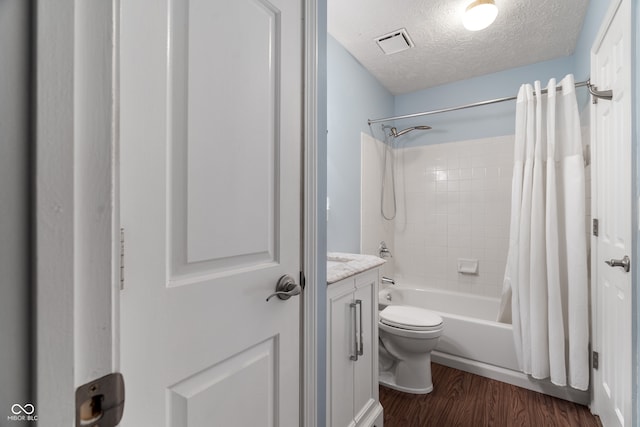 full bathroom with wood-type flooring, a textured ceiling, toilet, shower / bath combo with shower curtain, and vanity