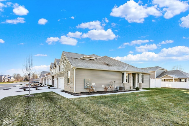 exterior space featuring a garage, a front yard, and central AC