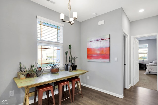 dining area with a notable chandelier and dark wood-type flooring