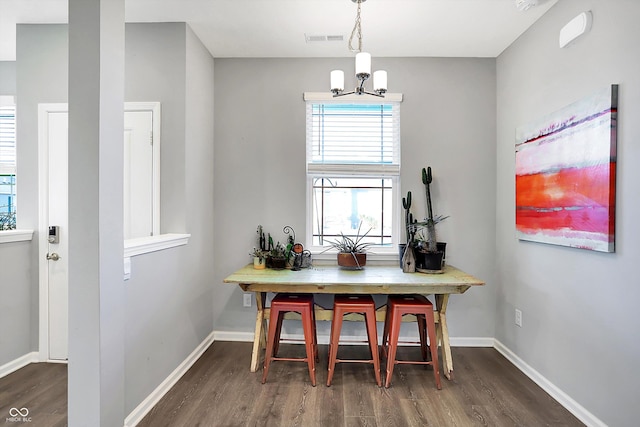 dining area featuring a notable chandelier and dark hardwood / wood-style floors