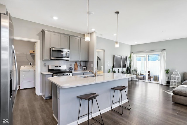 kitchen featuring pendant lighting, stainless steel appliances, dark hardwood / wood-style floors, and gray cabinetry