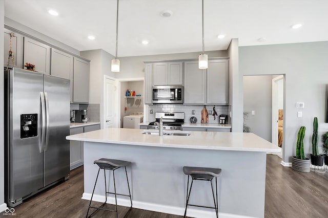 kitchen with gray cabinets, dark hardwood / wood-style floors, and appliances with stainless steel finishes