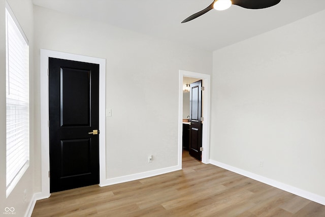 unfurnished bedroom featuring multiple windows, ceiling fan, and light wood-type flooring