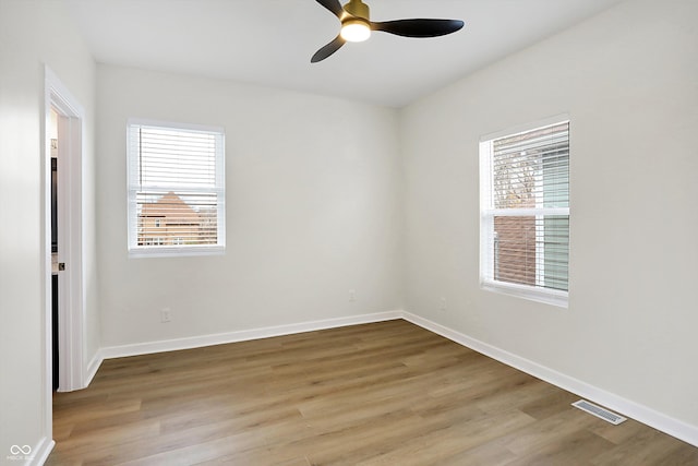 unfurnished room featuring ceiling fan, light hardwood / wood-style flooring, and a healthy amount of sunlight