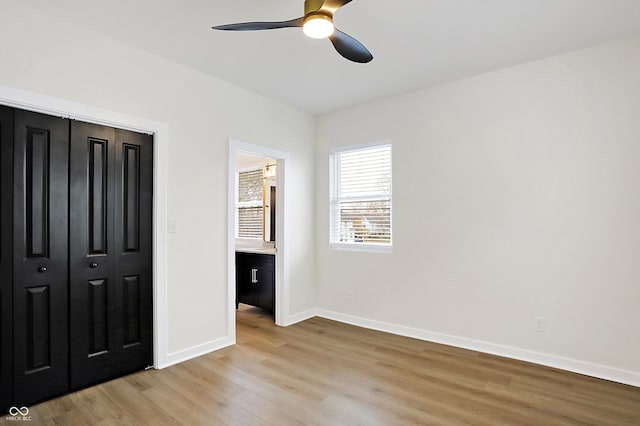 unfurnished bedroom with ceiling fan, light wood-type flooring, and a closet