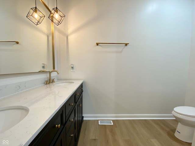 bathroom with toilet, vanity, and hardwood / wood-style flooring