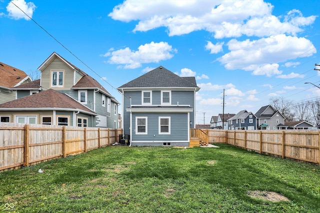 rear view of property with a lawn and central air condition unit