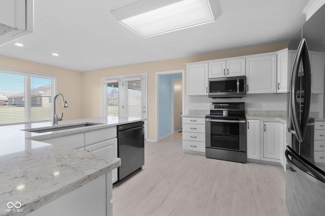 kitchen featuring white cabinets, sink, light hardwood / wood-style flooring, appliances with stainless steel finishes, and light stone counters