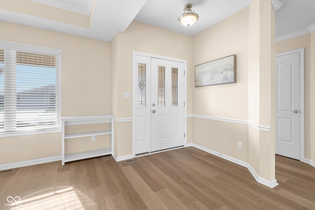 foyer with light hardwood / wood-style floors and ornamental molding