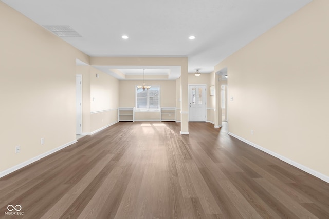 unfurnished living room with hardwood / wood-style floors and a chandelier