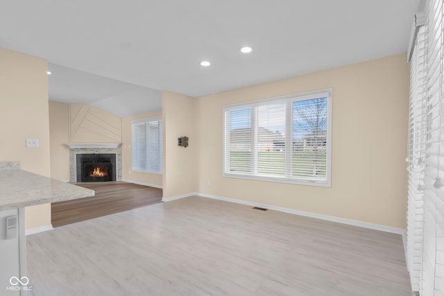 unfurnished living room featuring light hardwood / wood-style floors and lofted ceiling