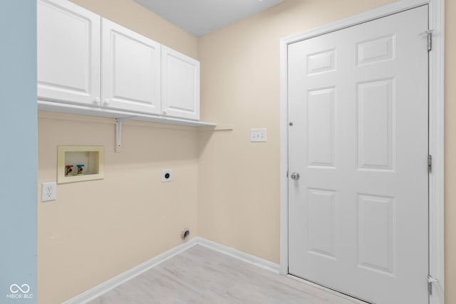 clothes washing area featuring electric dryer hookup, cabinets, washer hookup, and light hardwood / wood-style floors