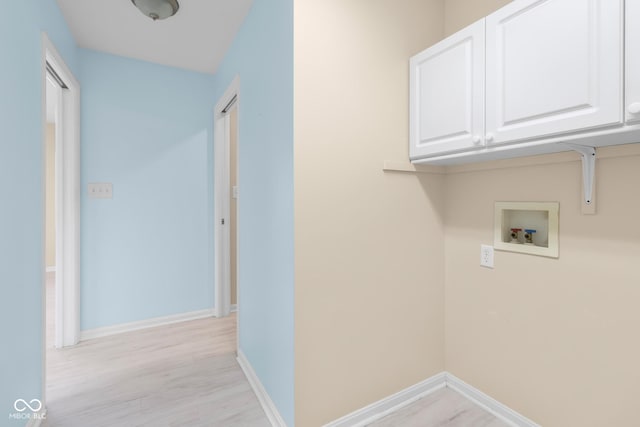 laundry area featuring cabinets, washer hookup, and light hardwood / wood-style floors