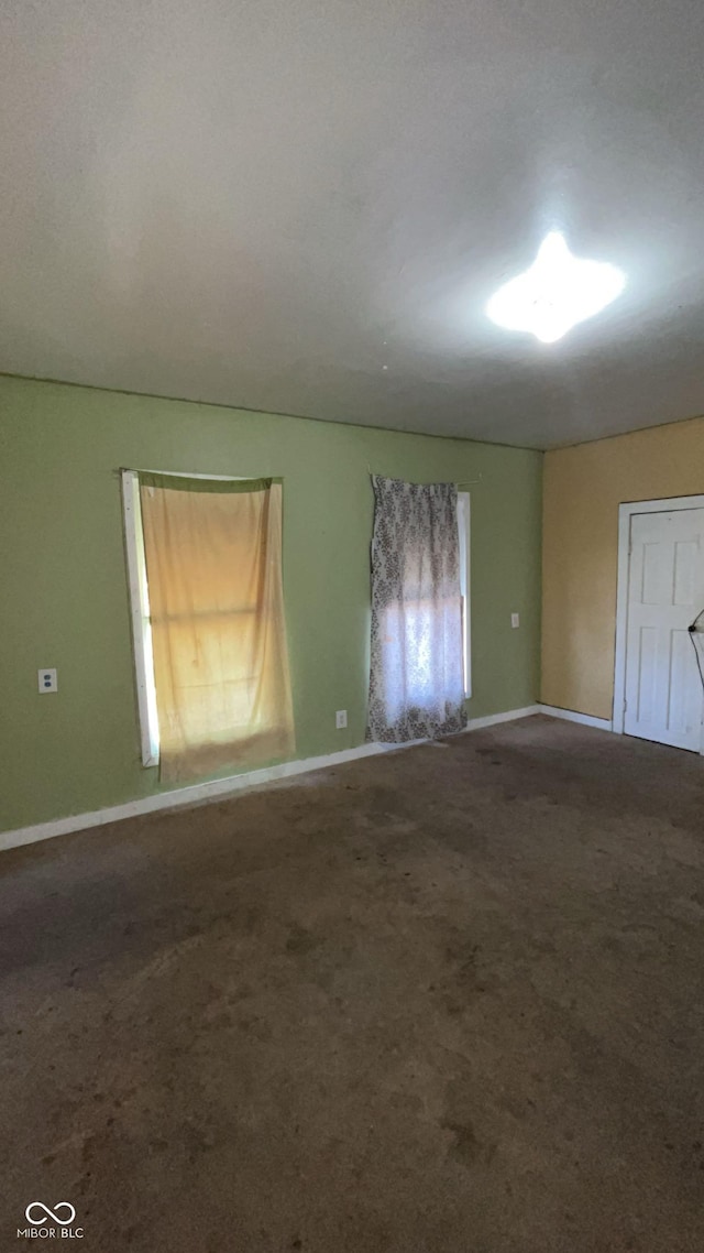 carpeted empty room featuring a wealth of natural light