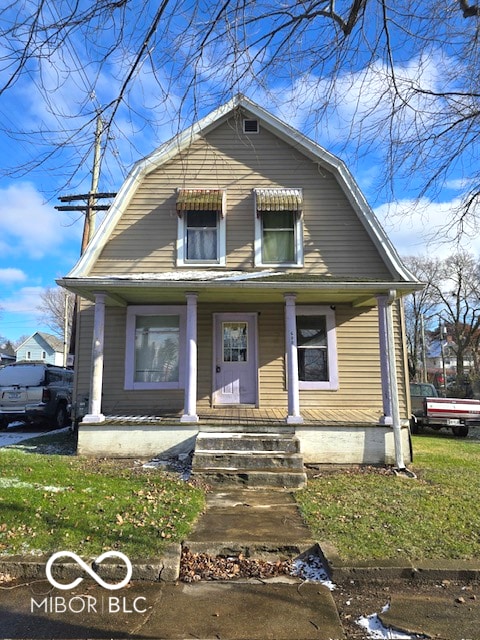 bungalow featuring covered porch and a front yard