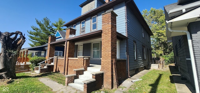 view of front of house with a porch and a front lawn