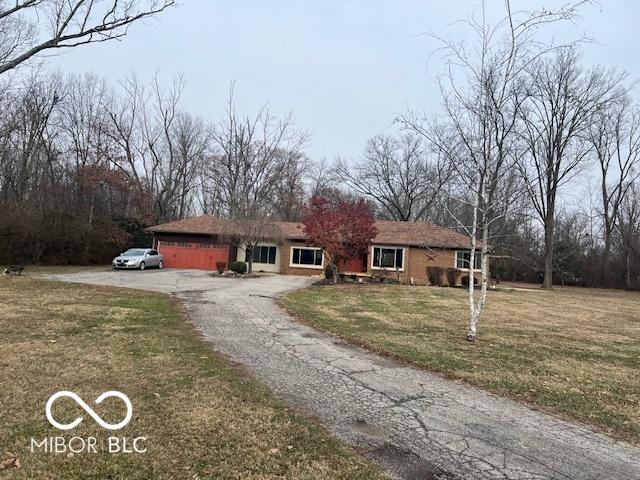 single story home with an attached garage, aphalt driveway, and a front yard