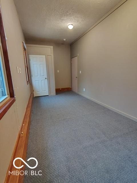 carpeted empty room with a textured ceiling