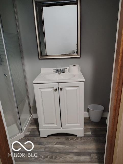 bathroom with hardwood / wood-style floors, vanity, and walk in shower