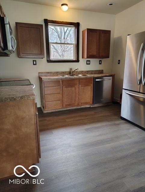 kitchen featuring sink, light wood-type flooring, and stainless steel appliances