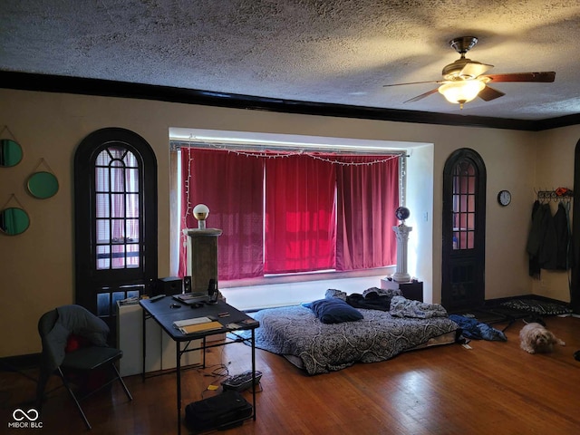 living room featuring hardwood / wood-style floors, ceiling fan, and a textured ceiling