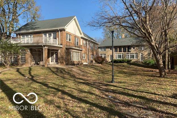 back of property with a balcony and a yard