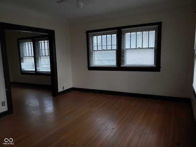 unfurnished room featuring ceiling fan and dark wood-type flooring