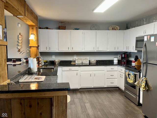 kitchen featuring kitchen peninsula, white cabinetry, and appliances with stainless steel finishes