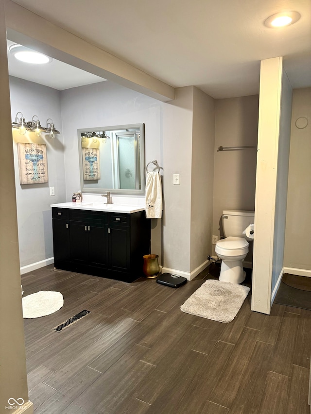 bathroom with hardwood / wood-style flooring, vanity, and toilet