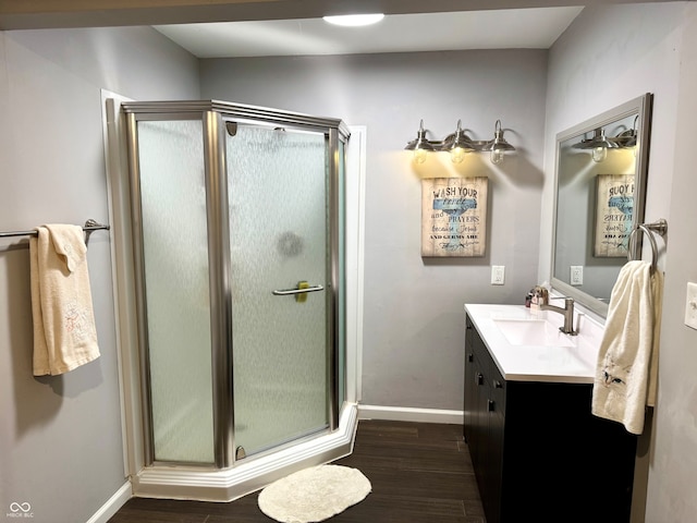 bathroom featuring hardwood / wood-style floors, vanity, and a shower with shower door