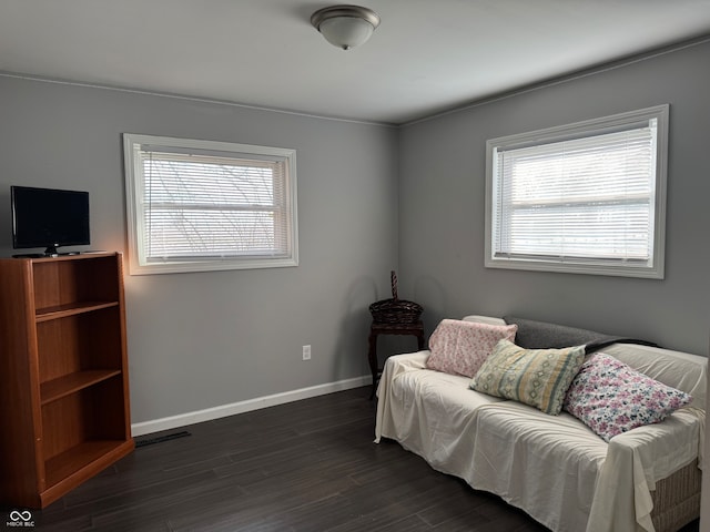 sitting room with plenty of natural light and dark hardwood / wood-style flooring