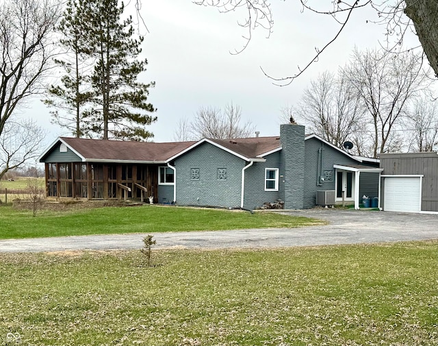 ranch-style house with a sunroom, central air condition unit, and a front lawn