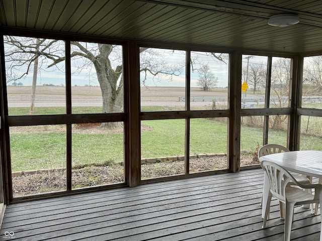 unfurnished sunroom with a healthy amount of sunlight and a rural view