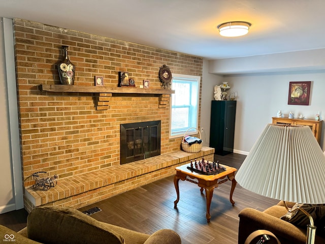 living room with a fireplace and wood-type flooring