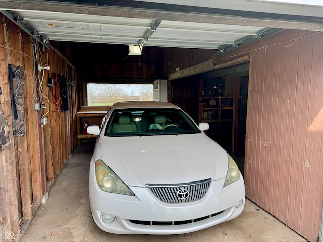 garage with a garage door opener and wood walls