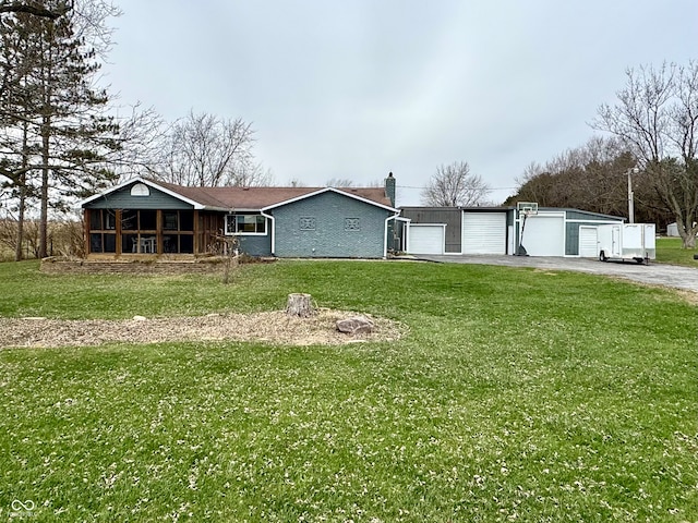 view of front of property featuring a sunroom, a garage, and a front yard