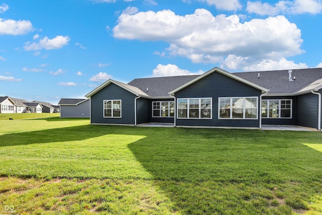 back of property featuring a lawn and a patio