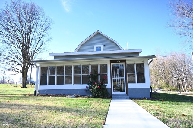 view of front of home featuring a sunroom and a front lawn