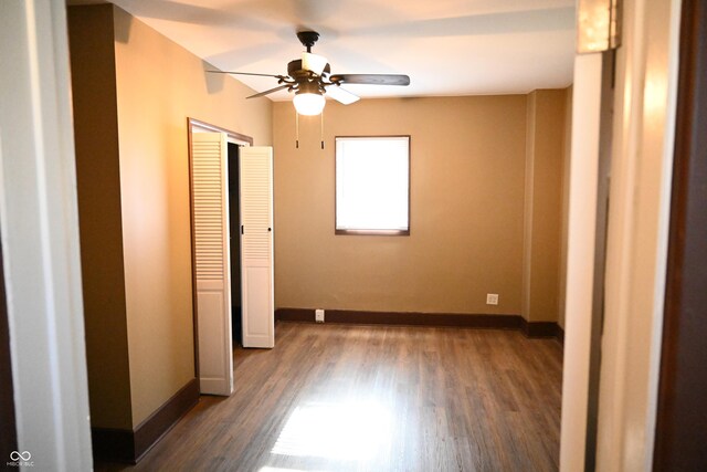 empty room featuring dark hardwood / wood-style flooring and ceiling fan