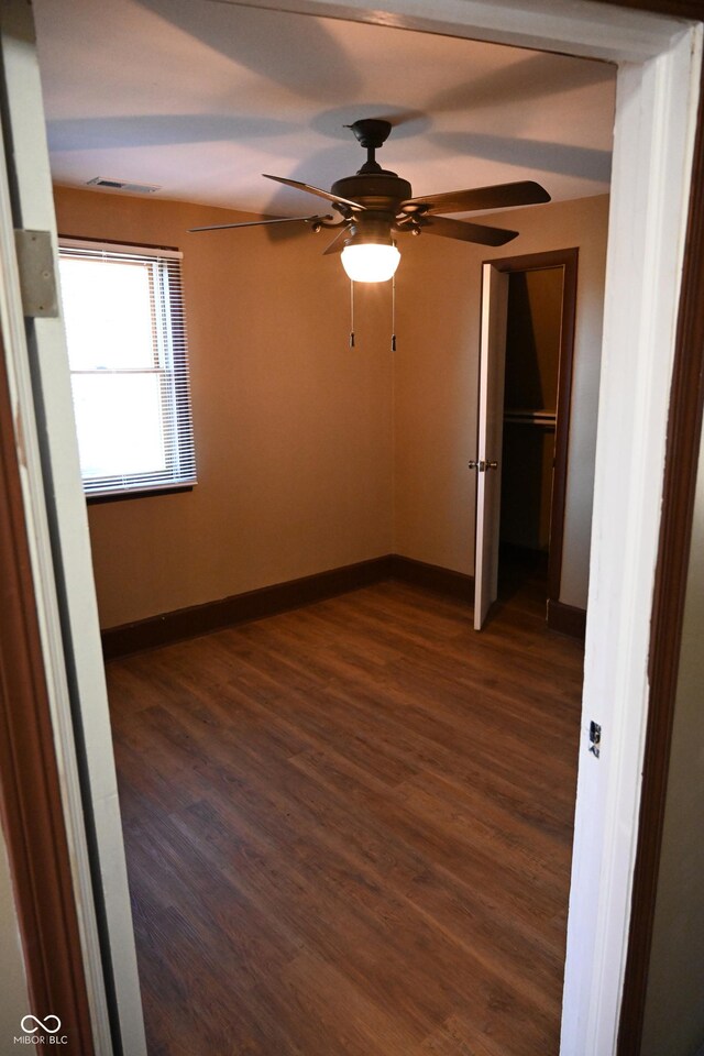 unfurnished bedroom featuring ceiling fan and dark hardwood / wood-style flooring